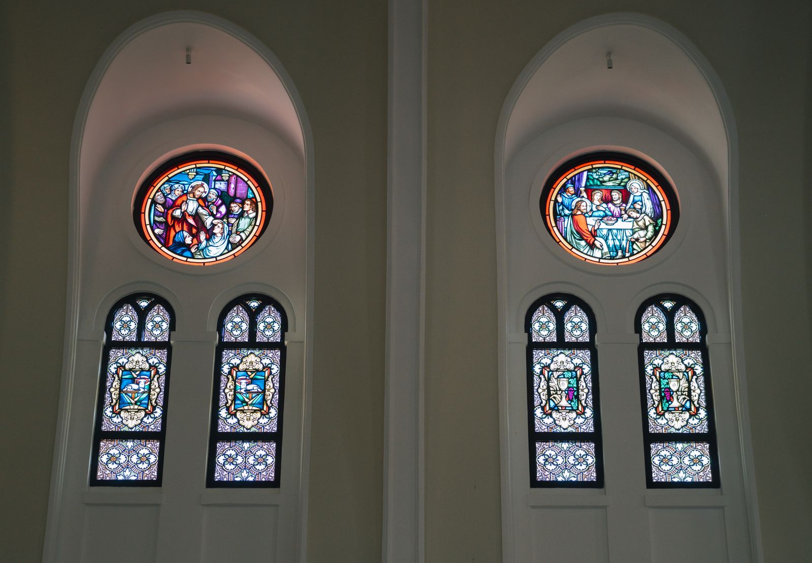 Deux baies à vitraux colorés sous des arcs